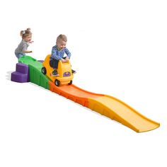 two small children playing on a colorful slide