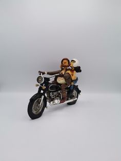 a figurine of two people on a motorcycle