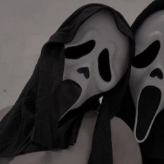 two masks with black and white faces covering them