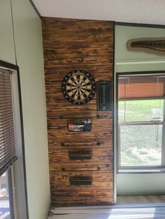 a dart board mounted to the side of a wall next to a window with blinds