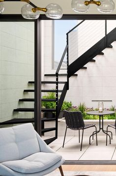 a living room filled with furniture next to a stair case