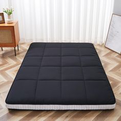 a black mattress is sitting on the floor