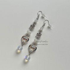 "Handmade Beaded Earrings ✿ Made with glass beads, glass crystal beads, and metal accents ✿ Silver, milky white, and iridescent clear ✿ The earrings are 2.6\" long (3.25\" total) Fish Hook Options ✿ The Titanium fish hook is hypoallergenic and ideal for sensitive skin ✿ The regular fish hook is made of nickel free metal, it is not hypoallergenic" Adjustable Nickel-free White Crystal Earrings, White Heart Beads Drop Earrings, White Czech Glass Beaded Dangle Earrings, White Drop Earrings With Heart Beads, White Metal Dangle Beaded Earrings, White Metal Dangle Crystal Earrings, White Czech Glass Dangle Earrings, Nickel-free White Crystal Metal Earrings, Nickel-free White Metal Crystal Earrings