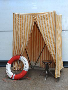 an orange and white striped tent next to a life preserver