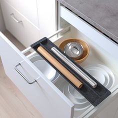 an open drawer with dishes and utensils in it