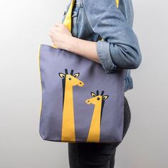 This handmade giraffe tote bag is full of fun and big in character and very practical too! A great gift for a giraffe lover! The animal canvas tote bag is perfect for a kids book bag, a school bag, shopping bag or a beach bag! An ideal gift for her. The front of the bag has two jungle giraffes illustrated with in yellows, blacks and whites on a grey background in a Scandinavian style. The reverse and handles are in a matching yellow canvas strong material. It is folded neatly and packaged with a Metallic Wrapping Paper, Kids Tote Bag, Black Wrapping Paper, Kids Totes, Lavender Bags, Animal Canvas, Grey Background, Gift Wrapping Services, Giraffes