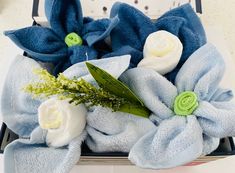 blue and white flowers in a box on a table with some cloth wrapped around it