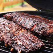 two steaks are being cooked on the grill