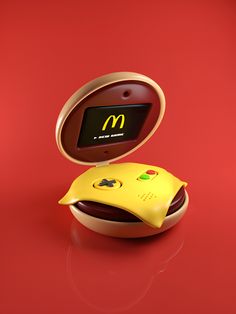 a mcdonald's electronic device is sitting on a red surface with its lid open