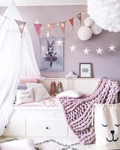 a bedroom decorated in pink and white with decorations on the ceiling, bedding, rugs and pillows