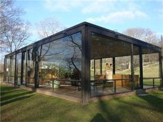 a glass house sitting on top of a lush green field