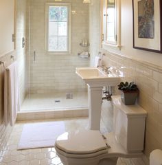 a bathroom with a toilet, sink and shower