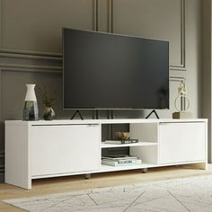 a flat screen tv sitting on top of a white entertainment center