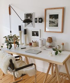 a white desk topped with a laptop computer sitting on top of a hard wood floor