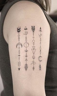 a woman with a tattoo on her arm showing different arrows and symbols in black ink