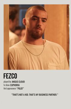 a man with a beard standing in front of a poster that says fezco