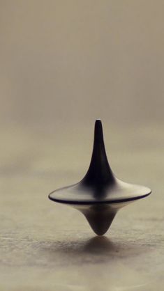 a small black object sitting on top of a table next to a white wall and floor