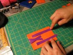 a person cutting out letters with scissors on a table