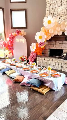 a table set up for a party with balloons and plates on the table in front of it