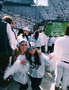 two girls in white and black outfits at a football game