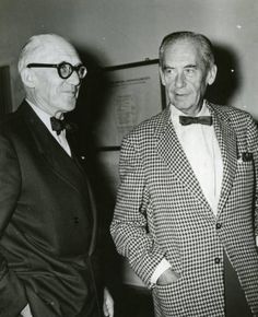 an old photo of two men in suits and bow ties standing next to each other