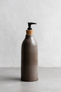 a brown bottle with a black pump on the top sitting on a white countertop