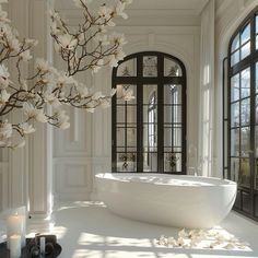 a large white bathtub sitting in the middle of a room next to two windows