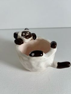 a small ceramic panda bear sitting in a bowl