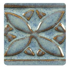 a blue and gold tile with leaves on it