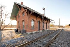 an old train station sits empty on the tracks