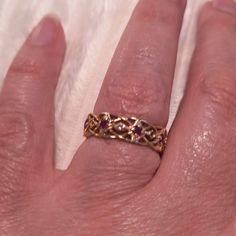 a person's hand with a gold ring on it