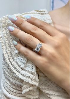 a woman's hand with two rings on her finger and one ring in the middle