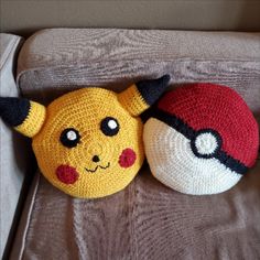 two crocheted pikachu and pokeball stuffed animals on a chair cushion