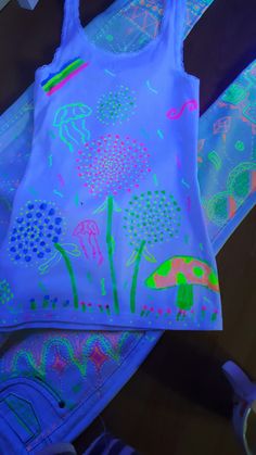 a tank top that is glow in the dark with flowers on it and blue background