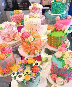 there are many different cakes on the table together, each decorated with flowers and polka dots