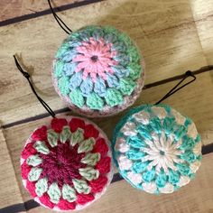 three crocheted balls sitting on top of a wooden floor next to each other