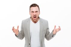 a man in a gray jacket is making an angry face with his hands while standing against a white background