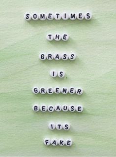 the words sometimes the grass is greener because it's fake on green paper