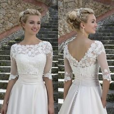 a woman wearing a white wedding dress with sheer sleeves and lace on the top, standing in front of some steps