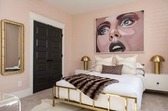 a bedroom decorated in pink and gold with a large painting on the wall above the bed