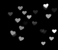 many white hearts floating in the air on a black background with space for your text