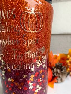 a red glitter tumbler with words written on it and pumpkins in the background