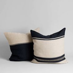 two black and white pillows sitting next to each other