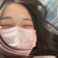 a woman wearing a face mask while laying down