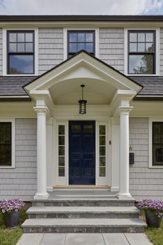 a house with white pillars and blue front door