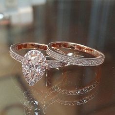 two wedding rings sitting on top of a table next to each other with diamonds in them