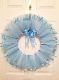 a blue tulle wreath hanging on the front door with a bow and ribbon around it