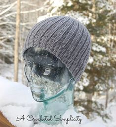 a mannequin head wearing a knitted hat in the snow