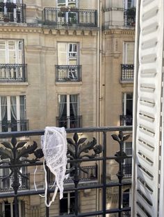 there is a white piece of cloth hanging on the balcony railing in front of an apartment building