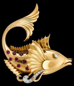 a gold fish brooch with red and white stones